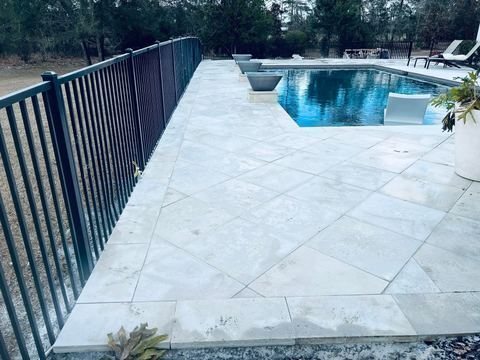 Travertine pool deck and pool pavers installed by Fénix Paver Landscape, Santa Rosa Beach FL