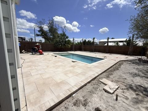 Travertine pool deck and pool pavers installed by Fénix Paver Landscape, Destin FL